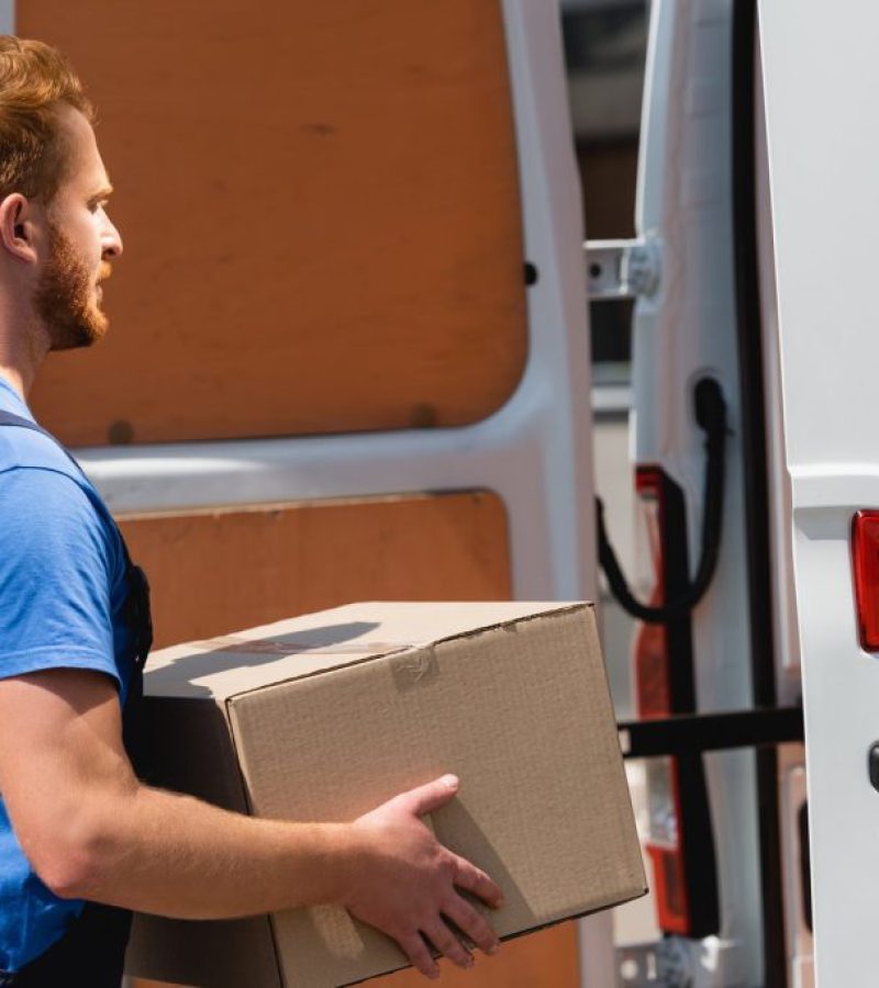 side-view-of-loader-holding-package-near-truck-on-2023-11-27-05-32-57-utc-1024x684